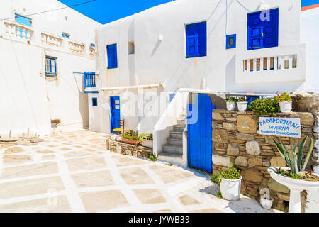 MYKONOS TOWN, GREECE - MAY 17, 2016: Entrance to traditional Greek tavern on witewashed street with blue windows in beautiful Mykonos town, Cyclades i Stock Photo