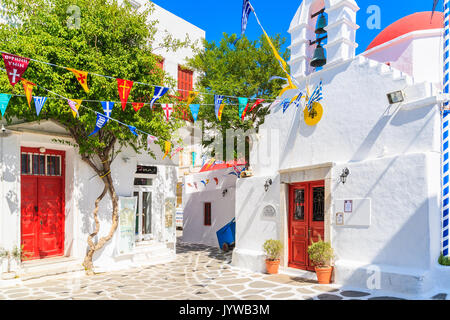 MYKONOS ISLAND, GREECE - MAY 17, 2016: Small square with church building on whitewashed street in beautiful Mykonos town, Cyclades islands, Greece. Stock Photo