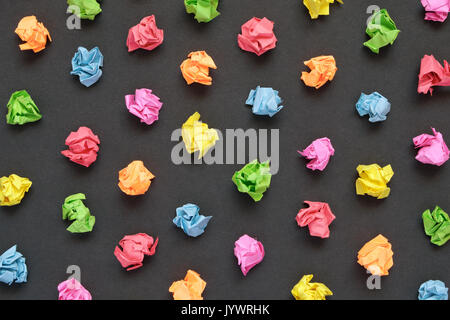 Colorful crumpled papers on black paper background Stock Photo