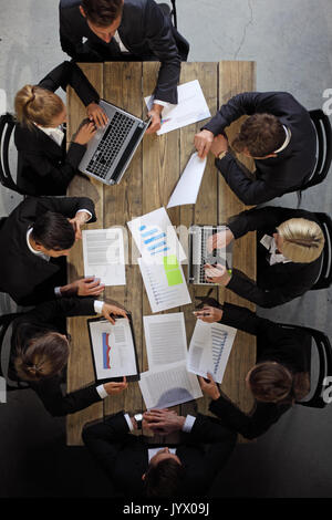 Business people analyzing financial documents showing income, charts and graphs, teamwork concept Stock Photo