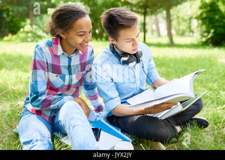 Couple of Students Doing Homework Outdoors Stock Photo