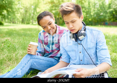 Students Doing Homework Outdoors on Lawn Stock Photo