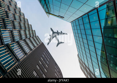 Airplane flying over skyscraper, low-angle view, London, England, United Kingdom Stock Photo