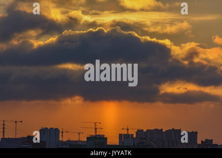 Orange clouds at sunrise over the city Stock Photo
