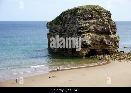 People on the beach at Marsden Rock a Rocky Formation of Limestone  off the North Sea Coast in South Shields England Stock Photo