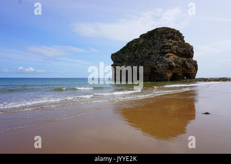 People on the beach at Marsden Rock a Rocky Formation of Limestone  off the North Sea Coast in South Shields England Stock Photo