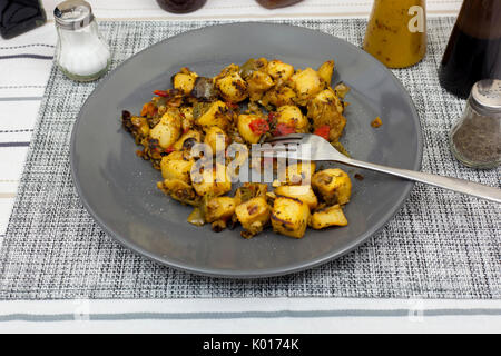 Plate of mixed mediterranean vegetables on the dinner table with a selection of condiments Stock Photo