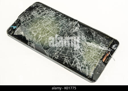 Mobile phone with a badly shattered screen after a serious fall. Stock Photo