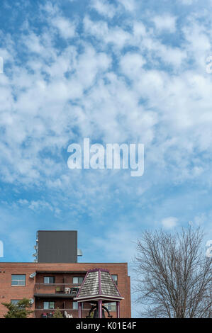 White clouds over apartment building Stock Photo