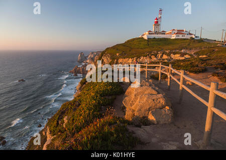 The colors of the sunset on the cape and lighthouse of Cabo da Roca overlooking the Atlantic Ocean Sintra Portugal Europe Stock Photo