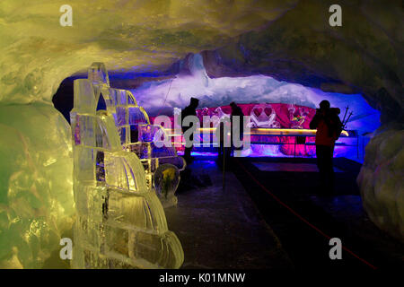 Tourists visiting the Glacier Grotto, the world's highest ice museum with its blue, frozen sculptures. A cable car lifts visitors to the top of the Kl Stock Photo