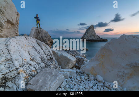 Dusk lights on cliffs framed by clear sea La Vela Beach Portonovo province of Ancona Conero Riviera Marche Italy Europe Stock Photo