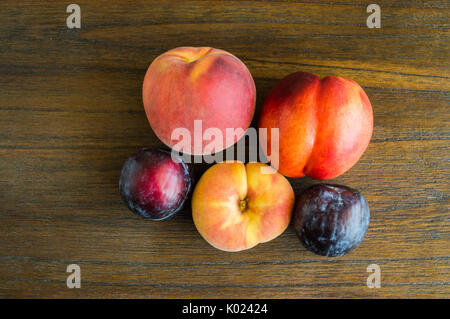 group of plums and peaches on a wooden table viewed from above Stock Photo