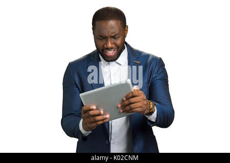 Black businessman surprised looking at computer tablet. Afro american manager hold touch screen tablet and smile with amazement. Stock Photo