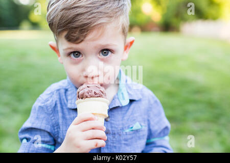 Portrait cute preschool boy eating ice cream cone Stock Photo