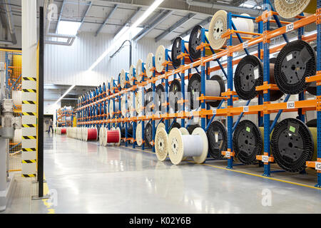Large spools on racks in fiber optics factory Stock Photo