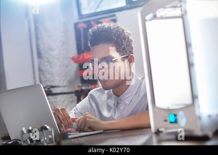 Focused young male designer using laptop Stock Photo
