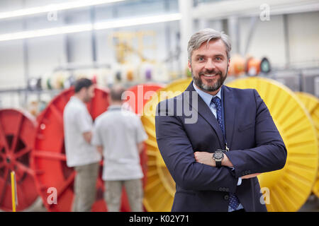 Portrait smiling, confident businessman in fiber optics factory Stock Photo