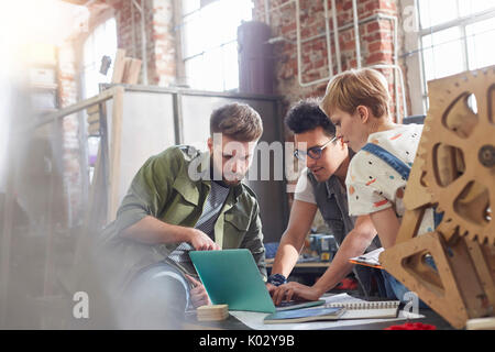 Designers working at laptop in workshop Stock Photo
