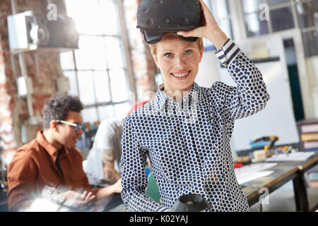 Portrait smiling female computer programmer wearing virtual reality simulator glasses Stock Photo