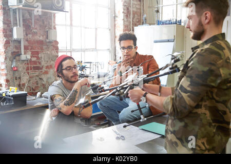 Designers meeting, examining drone in workshop Stock Photo