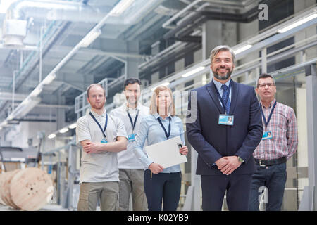 Portrait confident business owner and supervisors in fiber optics factory Stock Photo