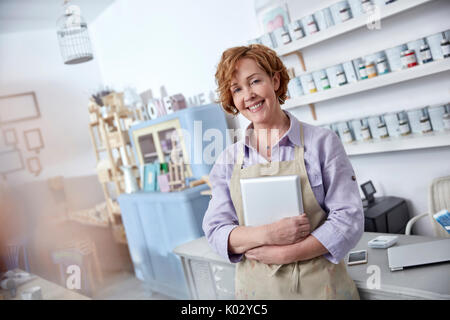 Portrait smiling, confident female business owner holding digital tablet in art shop Stock Photo