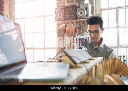 Male designer using power drill in workshop Stock Photo