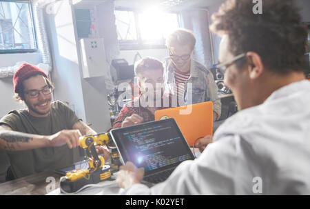 Computer programmers programming robotics in workshop Stock Photo