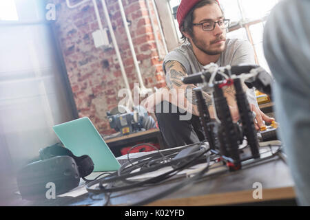 Male computer programmer programming electronics in workshop Stock Photo