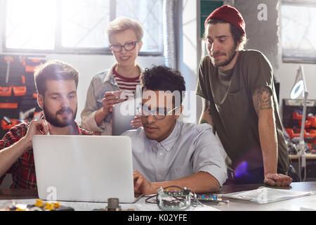 Designers meeting, working at laptop in workshop Stock Photo