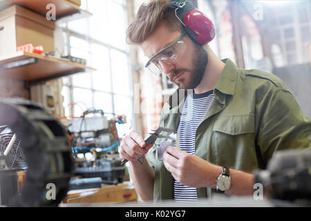 Male designer using caliper in workshop Stock Photo