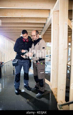 Carpenters Using Tablet Computer At Site Stock Photo