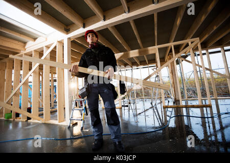 Portrait Of Carpenter Carrying Wood At Site Stock Photo