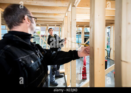 Carpenters Measuring Wooden Pillars At Site Stock Photo