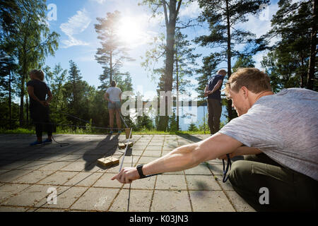 Man Picking Wooden Block With Rope While Playing With Friends Stock Photo