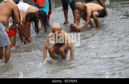 Kathmandu, Nepal. 21st Aug, 2017. Devotees take holy bath to perform religious rituals on the occasion of Kuse Aunsi, or Father's Day on the bank of Bagmati River at Gokarna Temple, Kathmandu. Kuse Aunsi is a Hindu festival in which pay respect and reverence to fathers with gifts and various delicacies and remember to deceased fathers. Credit: Archana Shrestha/Pacific Press/Alamy Live News Stock Photo