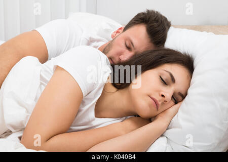 Portrait Of Young Couple Sleeping On Bed Stock Photo