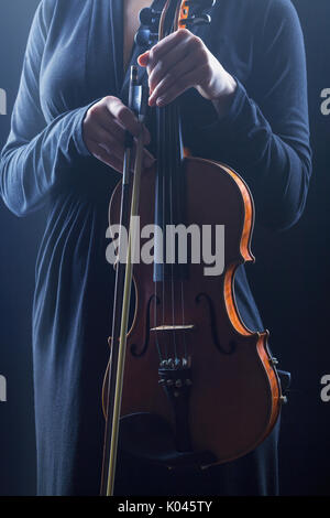 Violin music instrument of orchestra closeup with player hands on black Stock Photo