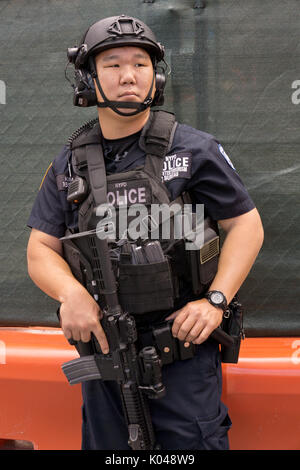 An armed Asian American counterterrorism policeman on patrol in Times Square, Manhattan, New York City Stock Photo