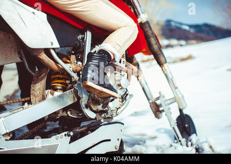 Feet on the bottom of the motorcycle in winter Stock Photo