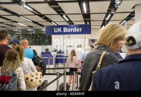 People at the UK border at Gatwick airport waiting to go through the epassport gates to check passport details.The system uses iris recognition. Stock Photo