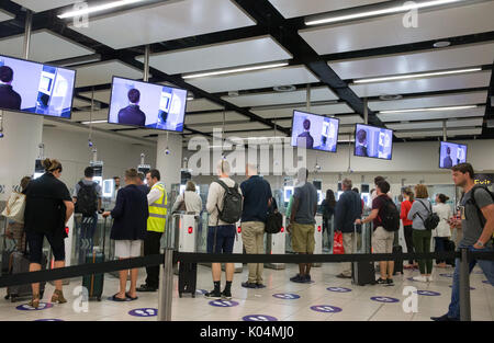 People at the UK border at Gatwick airport waiting to go through the epassport gates to check passport details.The system uses iris recognition. Stock Photo