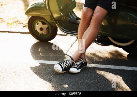 Cropped picture of young man standing near scooter outdoors. Stock Photo