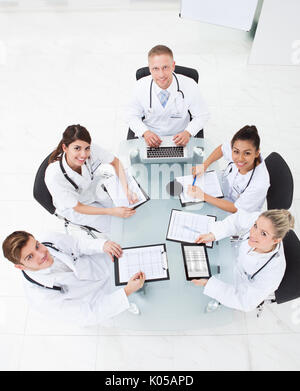 High angle view of doctors analyzing medical reports at desk in clinic Stock Photo