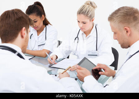 Team of doctors working at desk in clinic Stock Photo
