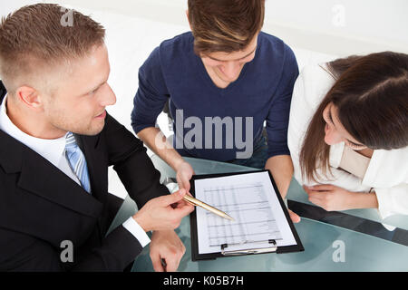 High angle view of financial advisor explaining investment plan to couple at office desk Stock Photo