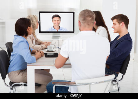 Business team attending video conference at desk in office Stock Photo