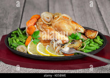 Roast chicken with vegetables in a pan Stock Photo