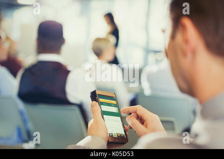 Businessman texting with cell phone in conference audience Stock Photo